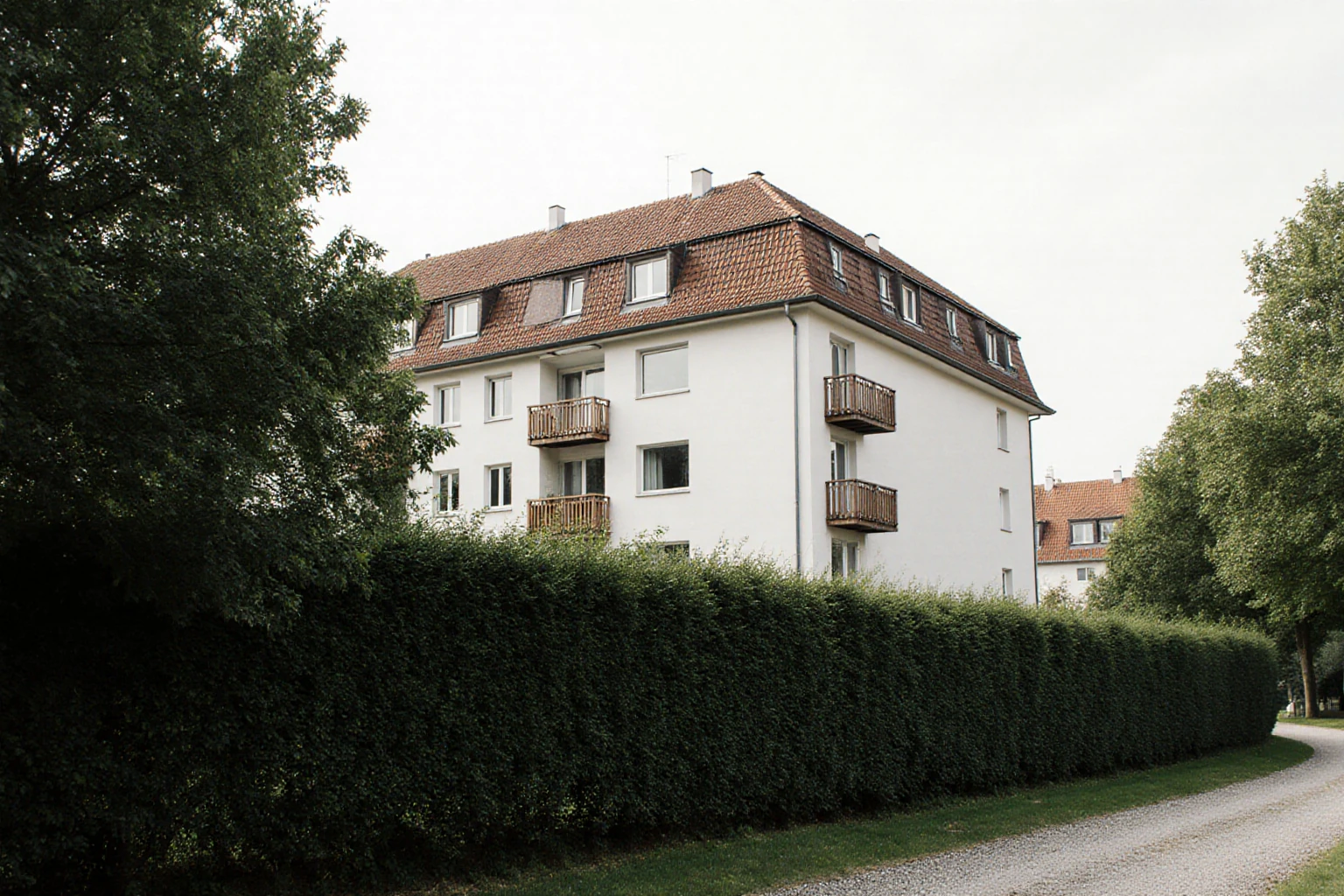 Hotelgebäude mit Zufahrt in mitteleuropäischer Umgebung